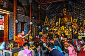 Chiang Mai - Wat Phra That Doi Suthep. Buddhist monk is blessing with lustral water visitors  inside the Northern vihan. 